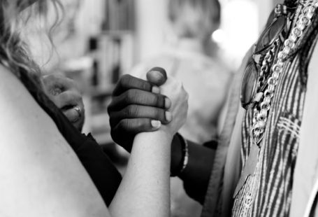 Cultural Diversity - grayscale photo of man and woman holding their hands