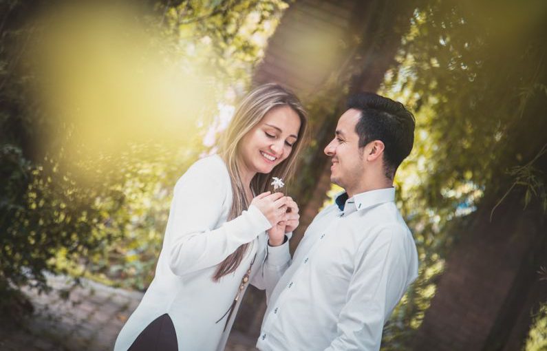 Introverts Engage - man giving white flower to woman surrounded by green trees