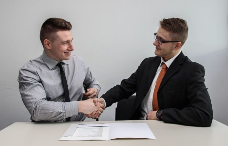 Partnership Benefits - two men facing each other while shake hands and smiling