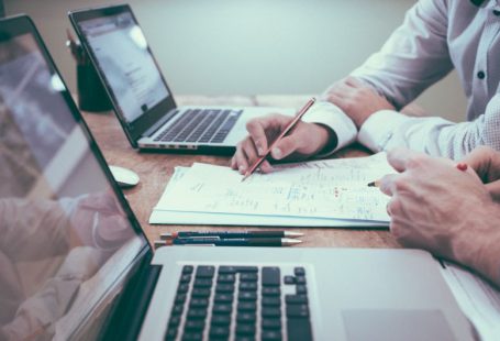 Budget Planning - person holding pencil near laptop computer