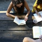 Volunteer Group - woman reading book while sitting on chair