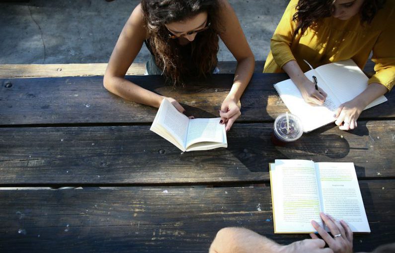 Volunteer Group - woman reading book while sitting on chair