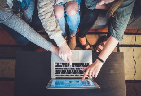 Community Transformation - three person pointing the silver laptop computer