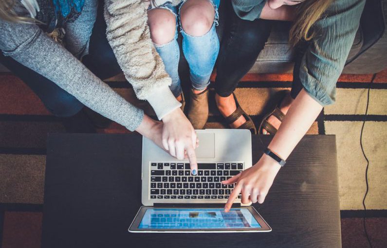 Community Transformation - three person pointing the silver laptop computer