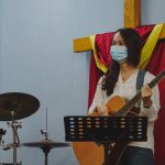 Youth Empowerment - woman in white long sleeve shirt playing guitar