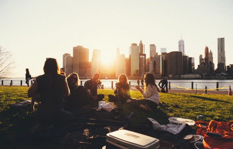 Community Bridge - people sitting on grass field