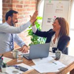 Partnership Success - man in white dress shirt sitting beside woman in black long sleeve shirt