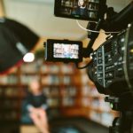 Video Production - person sitting in front bookshelf