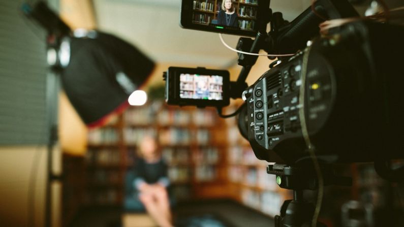 Video Production - person sitting in front bookshelf