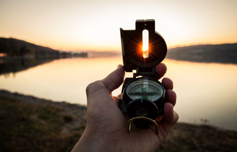 Algorithm Navigate - person showing black and white compass