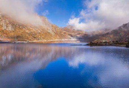 Momentum Maintain - brown and green mountains beside blue lake under blue sky during daytime