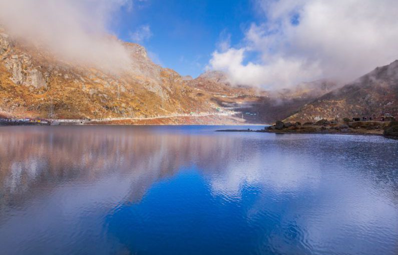 Momentum Maintain - brown and green mountains beside blue lake under blue sky during daytime