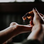 Self-care Tips - person holding amber glass bottle