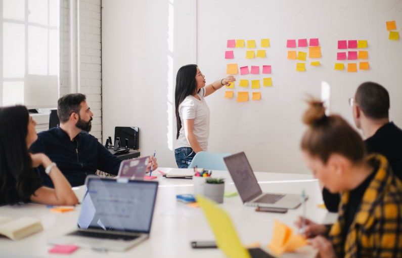 Visual Communication - woman placing sticky notes on wall